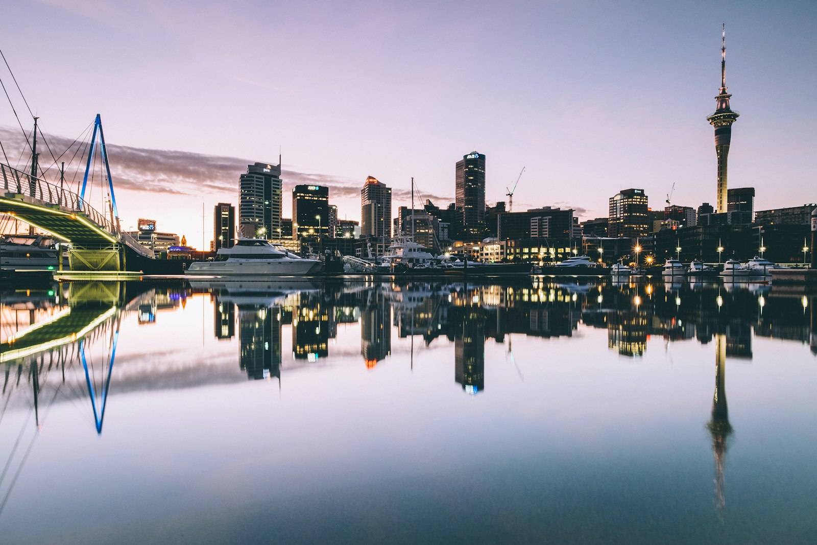 The Auckland skyline and Sky Tower reflected in still water at dusk